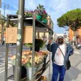 Un cartello attaccato alla parte posteriore del carretto riporta l��offerta del giorno�, ossia venti rose a soli tre euro